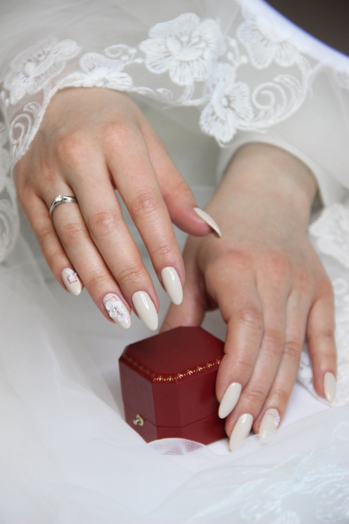 Main de mariée avec ongles élégants et bague de mariage