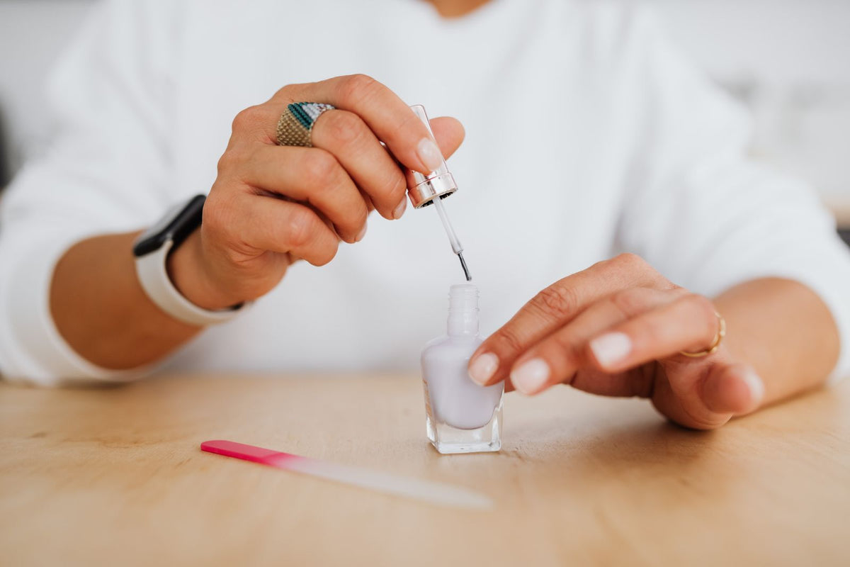 Application de vernis lilas sur une surface en bois avec lime à ongles